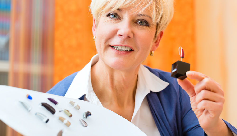 Lady showing the different styles of hearing aids available.